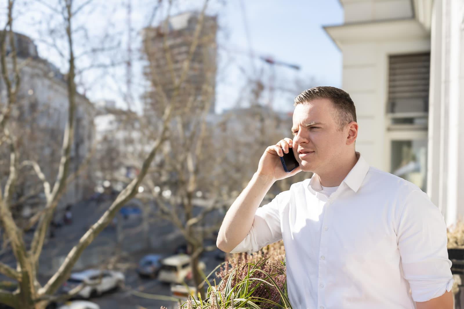 Karl Widiger telefoniert im Treppenhaus eines Altbaus